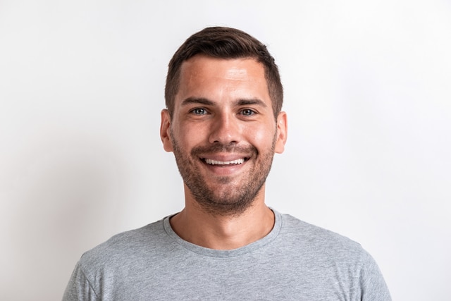 Closeup male studio portrait of happy man looking at the camera.- Image